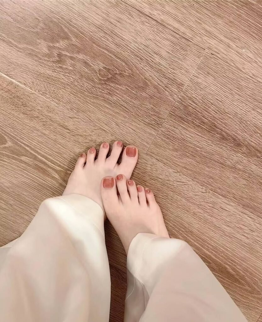 "2025 short toenail trends: minimalist geometric designs in earth tones with chrome accents, Korean-inspired negative space, low-maintenance styles."