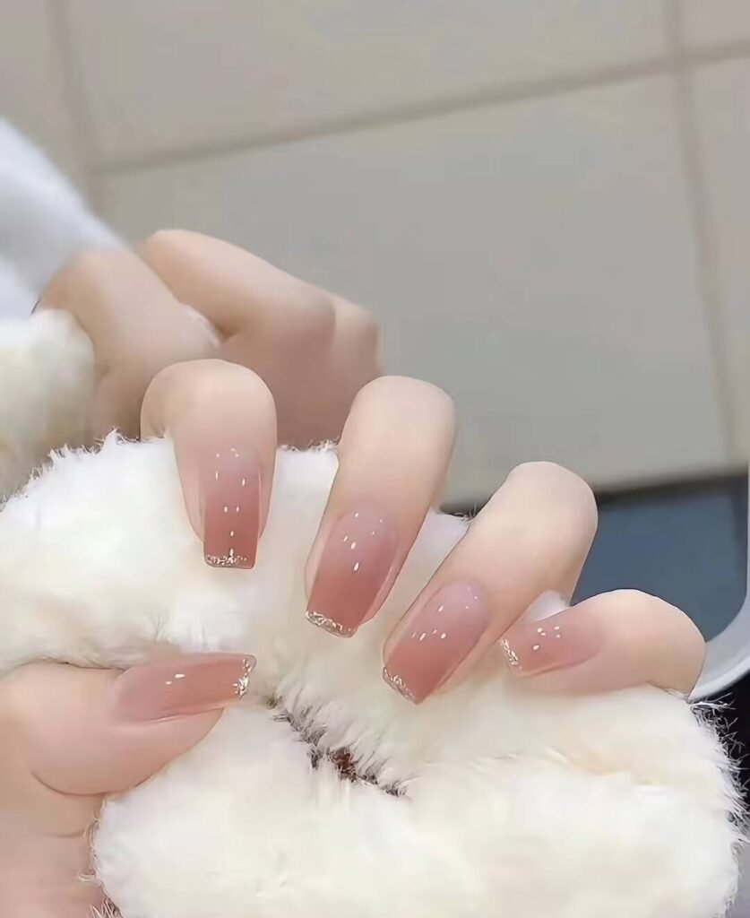 Short, elegant nail designs featuring minimalist styles like French tips, soft nude polish, and delicate gold accents on natural nails.