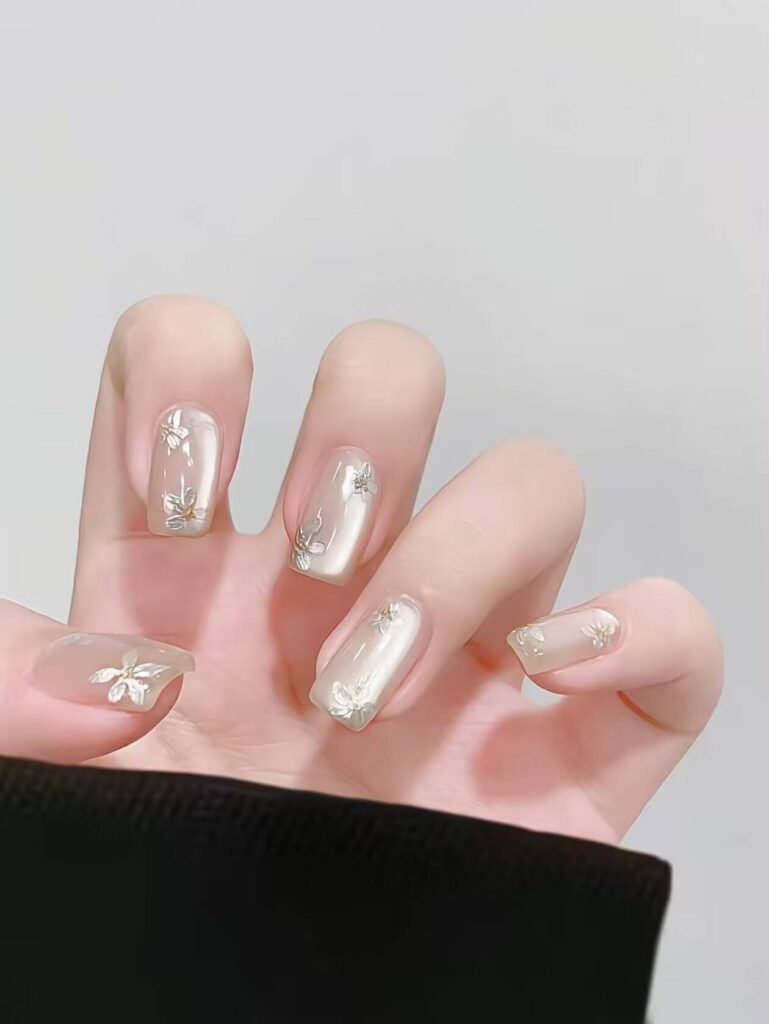 Minimalist spring nail 2025 trends: sheer blush base with subtle chrome half-moon accents.