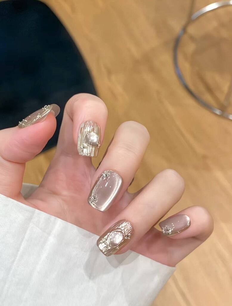 Minimalist spring nail 2025 trends: sheer blush base with subtle chrome half-moon accents.