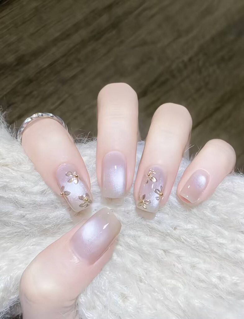 Minimalist spring nail 2025 trends: sheer blush base with subtle chrome half-moon accents.