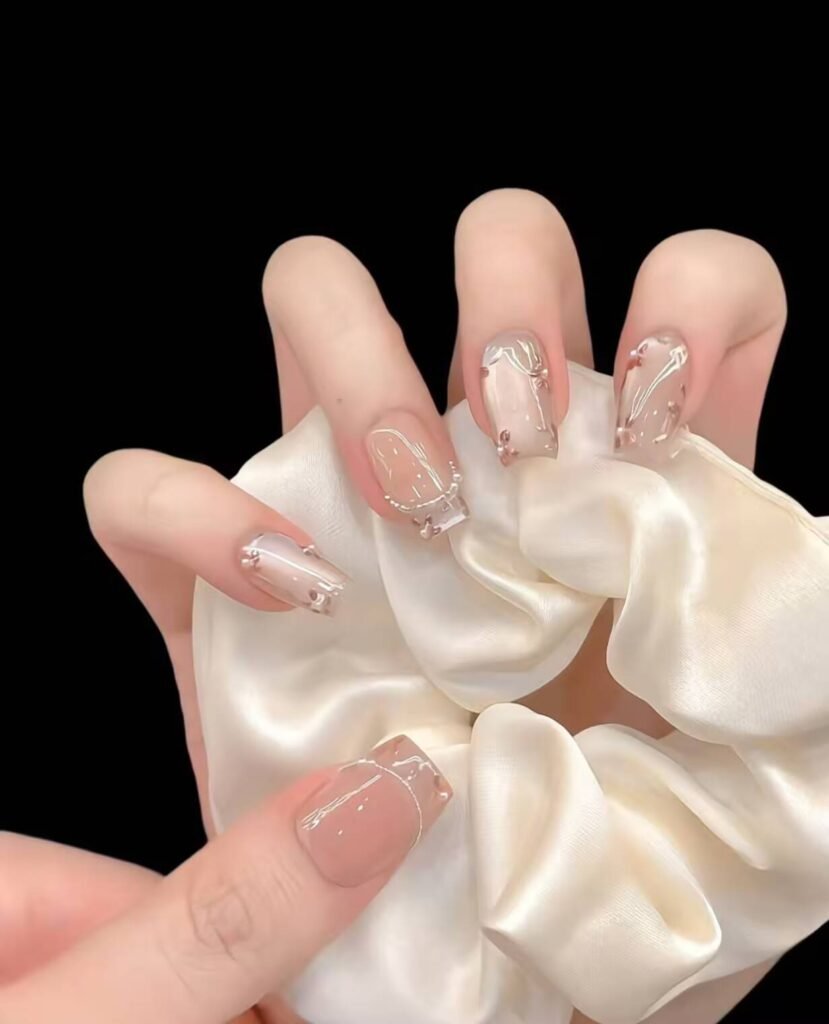 Minimalist spring nail 2025 trends: sheer blush base with subtle chrome half-moon accents.