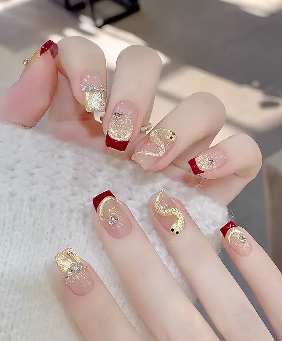 Short, almond-shaped nails showcasing current trendy designs: a soft gradient ombre with sparkling glitter accents and minimalist thin white lines.