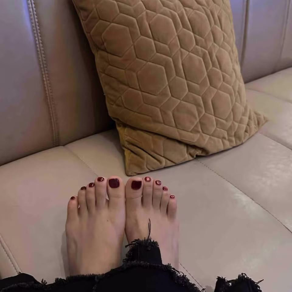 Luxury Toe Nail Trends featuring intricate gold foil accents, shimmering pearl embellishments, and a deep crimson ombré on perfectly pedicured toes.