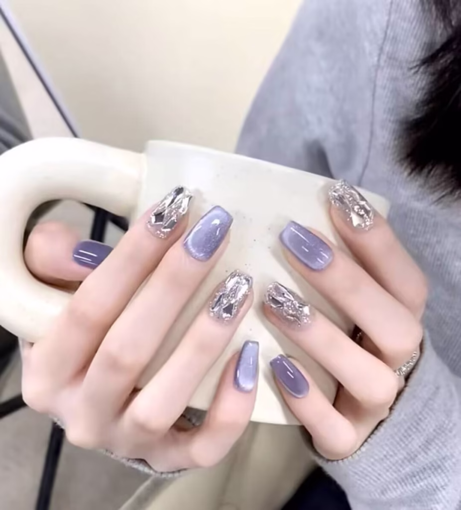 Skin Brightening Manicure Styles featuring pearlized nude polish with delicate glitter tips and subtle chrome accents.